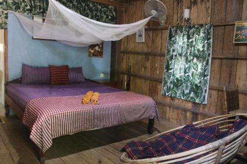 a bedroom with a bed with two shoes on it at Fish Island Bungalows in Kampot