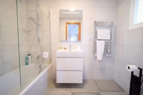 a white bathroom with a sink and a shower at Soleado adosado esquinero frente a piscina in Gran Alacant