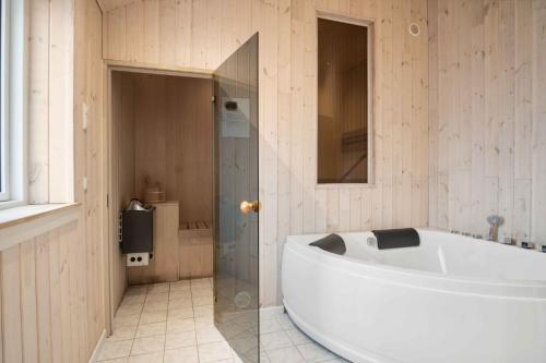 a bathroom with a tub and a glass shower at Modern Summer House In Pøt With Spa & Sauna in Sønderby