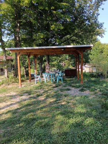 a wooden pavilion with a table and chairs in a field at Wild Camping Albareto in Albareto