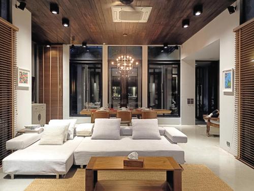 a living room with a large bed and a table at Chombua MaeWang ชมบัว in Chiang Mai
