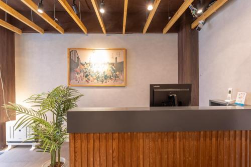 a reception desk with a picture on the wall at Tabist HOTEL UENO 39 in Tokyo