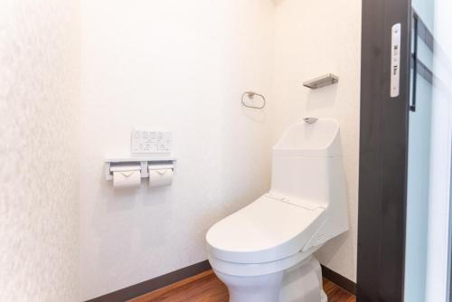 a bathroom with a toilet and two rolls of toilet paper at Tabist HOTEL UENO 39 in Tokyo