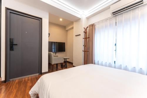 a bedroom with a white bed and a sliding door at Tabist HOTEL UENO 39 in Tokyo