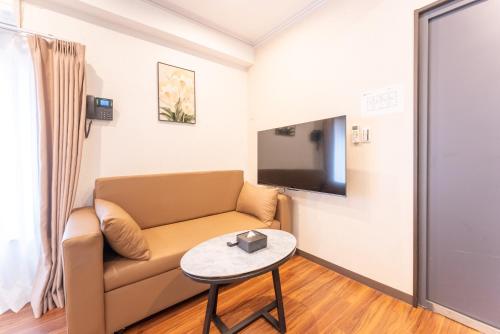 a living room with a couch and a table at Tabist HOTEL UENO 39 in Tokyo