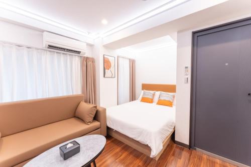a hotel room with a bed and a couch at Tabist HOTEL UENO 39 in Tokyo