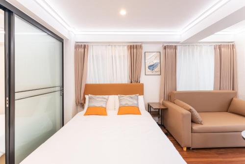 a bedroom with a bed and a couch at Tabist HOTEL UENO 39 in Tokyo