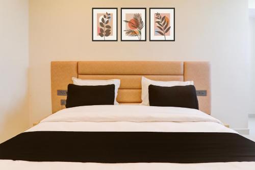 a bedroom with a large bed with three pictures on the wall at Collection O Siddharth Near A to Z Electronics in Kānpur