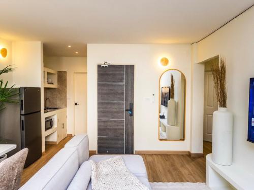 a living room with a white couch and a sliding door at 2 Bedroom for 4 guests Private in center of Sathorn in Bangkok