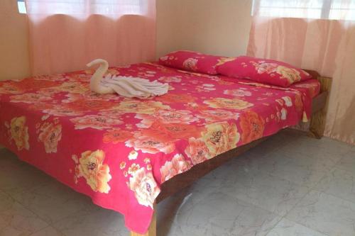 a bedroom with a bed with a swan on it at Casa Paliton Siquijor near Beach in Siquijor