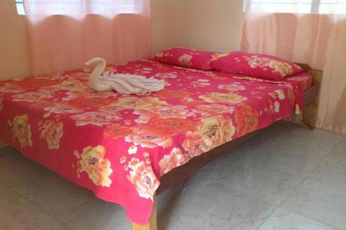 a bedroom with a bed with a swan on it at Casa Paliton Siquijor near Beach in Siquijor