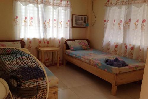 a small room with a bed and curtains at Casa Paliton Siquijor near Beach in Siquijor