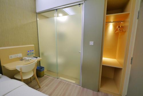 a glass shower in a room with a bed and a desk at 33 Boutique Hotel Bandar Sunway in Petaling Jaya