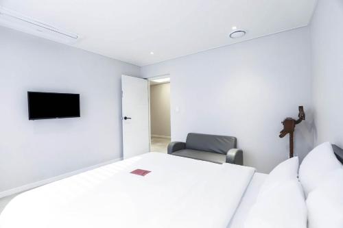 a bedroom with a bed and a chair at Busan Songjeong Hotel Hongdan in Busan