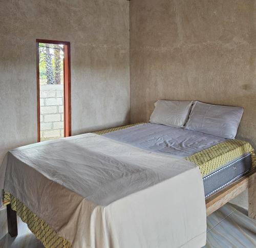 a large bed in a room with a window at Mia's House in Nembrala