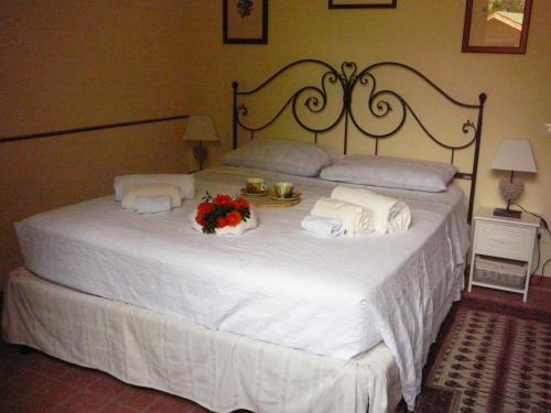 a bedroom with a white bed with flowers on it at Agriturismo Ca' di Mazza in Monzuno
