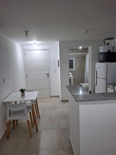 a kitchen with a counter and a table and a room at Departamento Pia in Neuquén