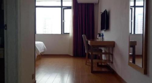 a room with a desk and a table and a window at GreenTree Inn Shangrao Qianshan hekou old town Xinjiang longting shell hotel in Shangrao