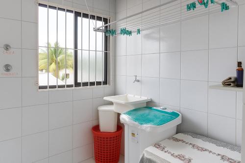a bathroom with a toilet and a sink and a window at Rua Projetada 07-lote recreio apartamento 5 loteamento recreio sul barra do Sirinhaém Condomínio residencial barra forte II in Sirinhaém