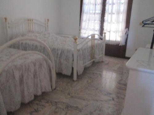 Barros da Fonte SantaにあるVivendas Costaの大理石フロアのベッドルーム1室(ベッド2台付)