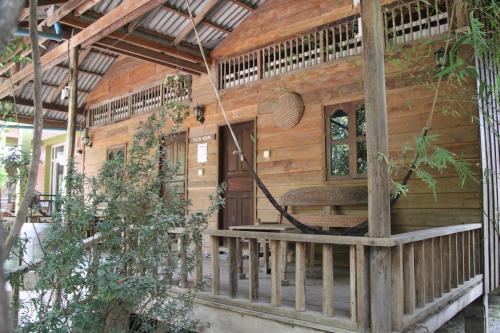 a log cabin with a porch and a swing at Fish Island Bungalows in Kampot