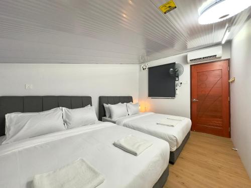 una piccola stanza con due letti e una tv di Spacious 2 Storey Homestay Tanjung Bungah 25Pax by 3C a Tanjung Bungah