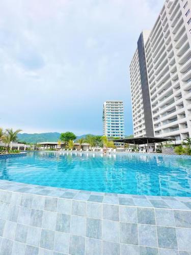 a large swimming pool with blue water in front of buildings at Exclusiva Suite Frente al Mar in Santa Marta