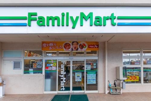 a familymart store with a sign on the front of it at Kahoo House in Nago