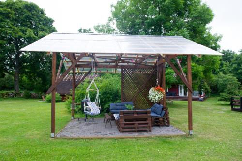 a gazebo with a bench and a swing at Käspri Farmstay in Koguva