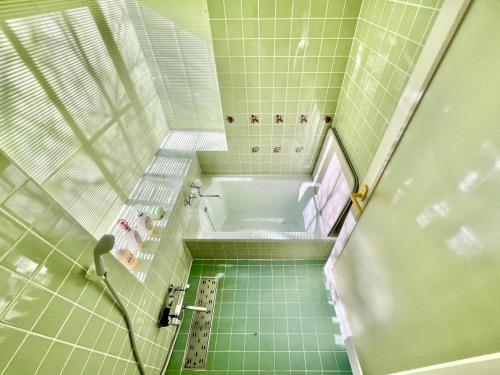 a small bathroom with a tub and a shower at 花の街589# Nature Escape BBQ in Tsumagoi