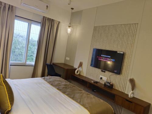 a hotel room with a bed and a flat screen tv at Pushpam Sanskruti Resort Karjat- Pure Veg in Karjat