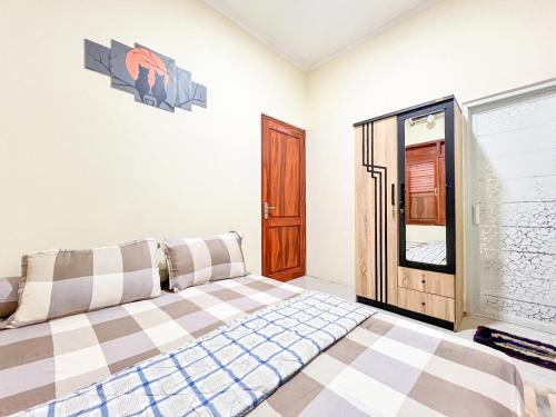 a bedroom with a bed and a window at Joglo Prambanan C2 in Bugisan