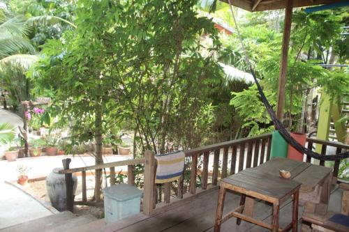 a wooden porch with a wooden table and a chair at Fish Island Bungalows in Kampot