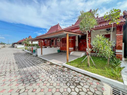a house with a cobblestone street in front of it at Joglo Prambanan C2 in Bugisan