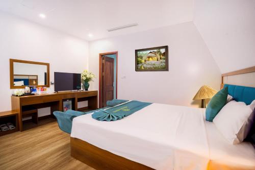 a bedroom with a bed and a desk with a computer at Crystal Holiday Ha Long Hotel in Ha Long