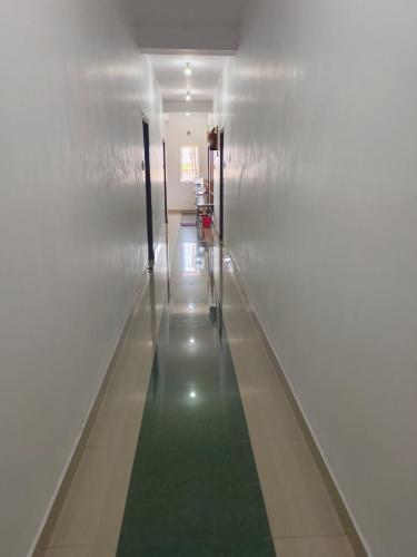 a hallway with a green floor in a building at Haleema Residency in Dharmapuram