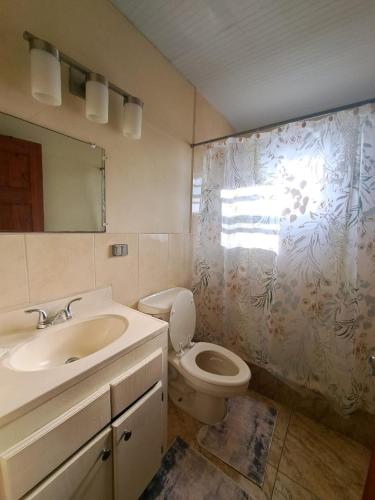 a bathroom with a sink and a toilet and a mirror at Etinoff's Apartments in Sutherlands Development