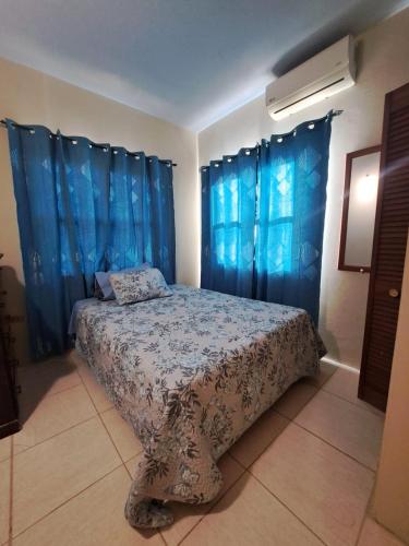 a bedroom with a bed with blue drapes at Etinoff's Apartments in Sutherlands Development