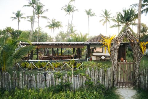 a house on the beach with palm trees at Aldeia Setemares Bangalôs - Praia do Sargi - Serra Grande in Serra Grande
