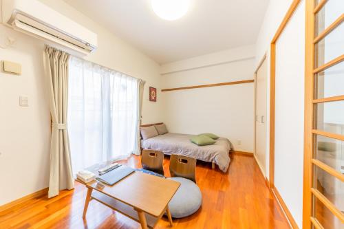 那覇市にあるCasa Leo ASATO カサレオ安里のベッドとテーブルのあるリビングルーム