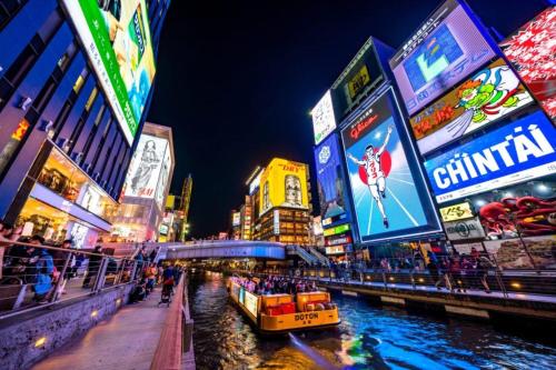 a boat in a river in a city at night at Nipponbashi Luxe Hotel in Osaka