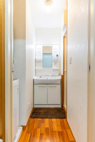 a small bathroom with a sink and a wooden floor at Casa Leo ASATO カサレオ安里 in Naha