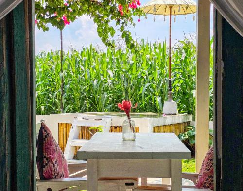 a table with a vase with a flower on a patio at Janur Bungalow in Borobudur