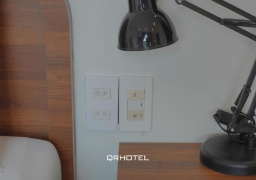 a lamp on a desk next to a light switch at QR Hotel Dalat in Xuan An