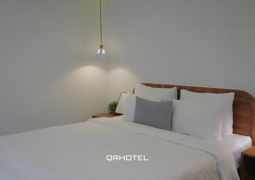 a bedroom with a white bed with white pillows at QR Hotel Dalat in Xuan An