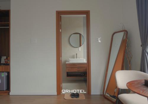 a bathroom with a mirror and a sink at QR Hotel Dalat in Xuan An