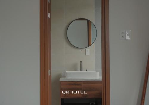 a bathroom with a sink and a mirror at QR Hotel Dalat in Xuan An