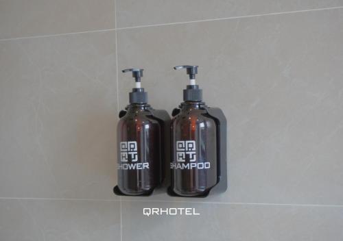 two bottles of disinfectants are sitting on a wall at QR Hotel Dalat in Xuan An