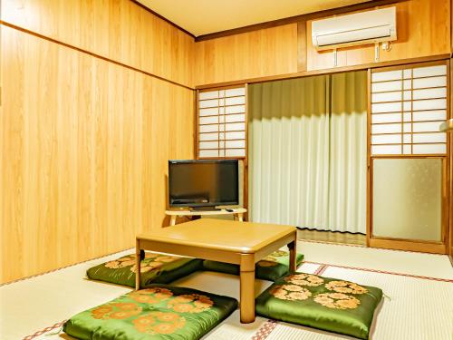 a living room with a table and two ottomans at The M OTAMACHI in Nakatsugawa