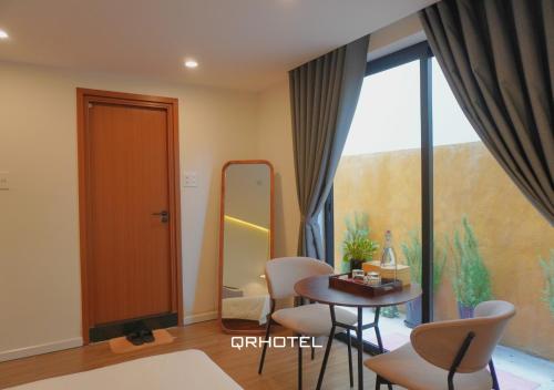 a room with a table and chairs and a mirror at QR Hotel Dalat in Xuan An